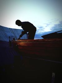 Low angle view of woman standing against sky