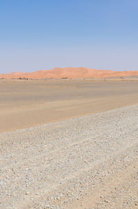 Scenic view of desert against clear blue sky