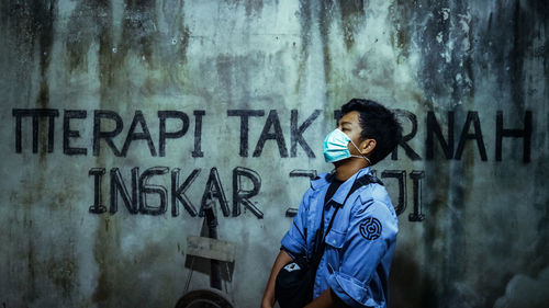 Woman standing against graffiti wall