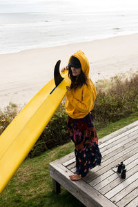 Female surfer prepares her surfboard for adventure