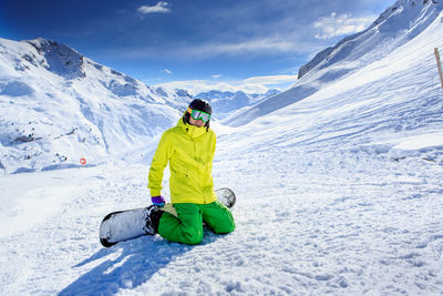 Portrait of smiling young man skiing on snowcapped mountains during winter