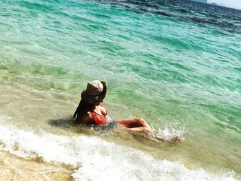 Rear view of man sitting in sea