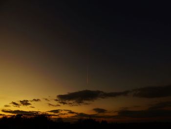 Low angle view of vapor trails in sky during sunset