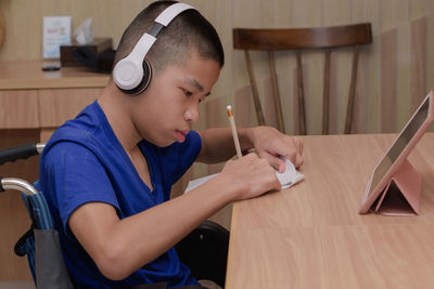 Boy writing on paper at table