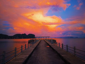 Pier over sea against sky during sunset