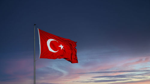 Low angle view of flag against blue sky