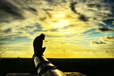 Sun shining through clouds over sea