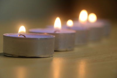 Close-up of illuminated tea light candles on table