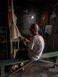 Senior man holding net while sitting on bench