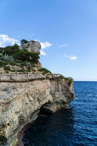 Rock formation in sea against sky