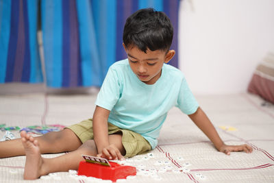 Side view of boy playing with toy blocks at home