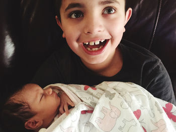 Close up of happy new brother holding new baby sister