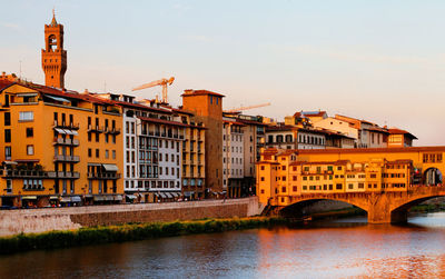 Bridge over river against buildings in city