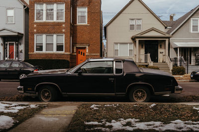 Car on street by buildings in city