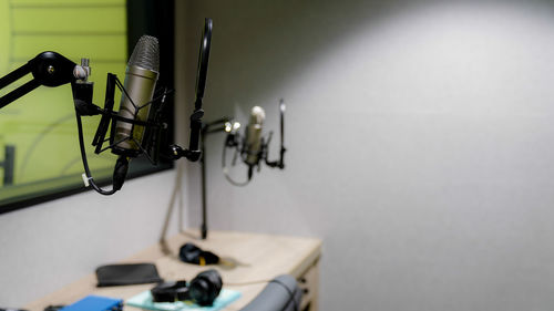 Close-up of electric lamp on table against wall