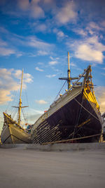 Sailboats moored on sea against sky