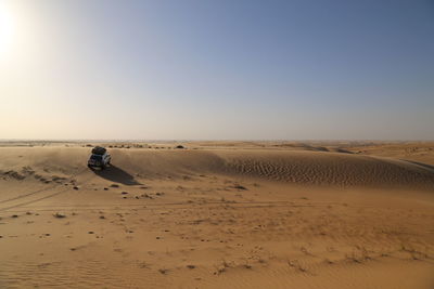 Scenic view of desert against clear sky during sunset