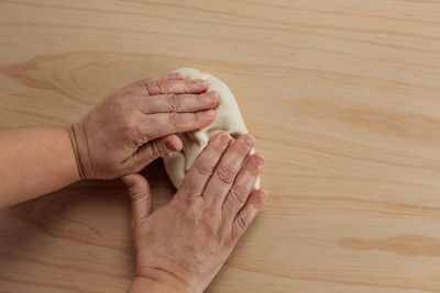 High angle view of couple hands on table