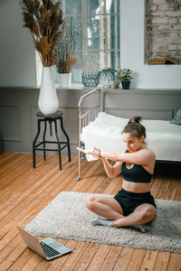 A strong and beautiful sports fitness girl in sportswear meditates in lotus position, resting 