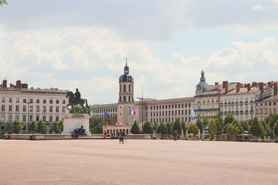 Buildings in city against cloudy sky