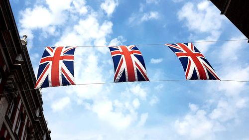 Low angle view of flag against blue sky