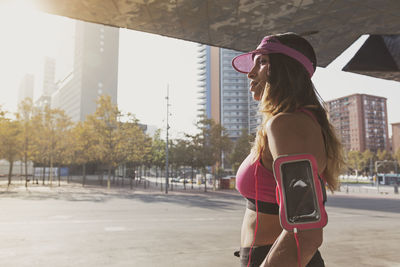 Young woman using mobile phone in city