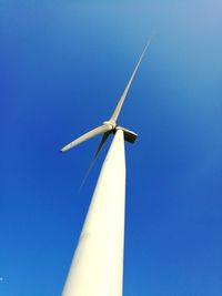 Low angle view of wind turbine against blue sky