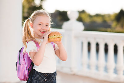 Portrait of cute girl holding hamburger