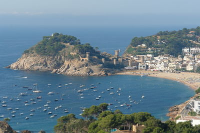 High angle view of city by sea against sky