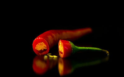 Close-up of red chili peppers on black background
