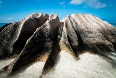 Rock formation on beach against sky