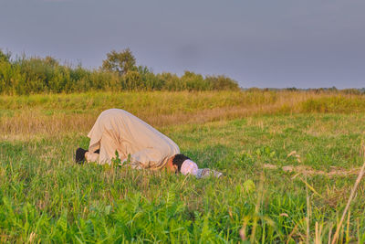 Side view of person on field against sky