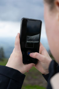 View over the soulder of a person taking a 360 degree photo with a smartphone