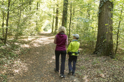 Rear view of women walking in forest