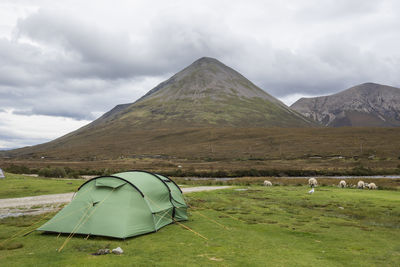 Tent on field by mountain against sky