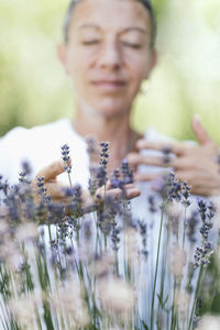 Close-up of woman holding flower in garden