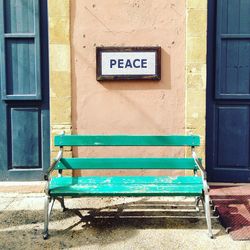 Empty bench against blue wall