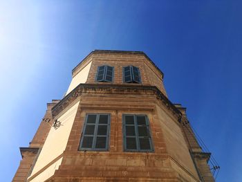 Low angle view of historic building against blue sky