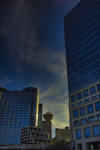 Low angle view of modern buildings against sky at sunset