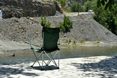 Chair on rock by lake