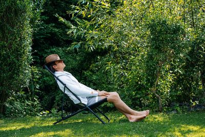 Man with straw hat relaxing on chair in the garden