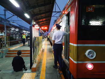 Rear view of people on railroad station platform