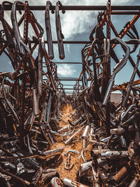 Close-up of rusty metal wheel on field against sky