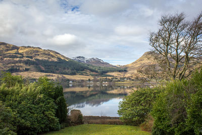 Scenic view of lake and mountains against cloudy sky