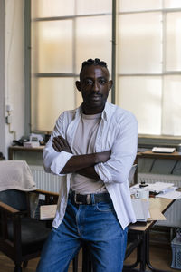 Portrait of confident businessman with arms crossed at workshop