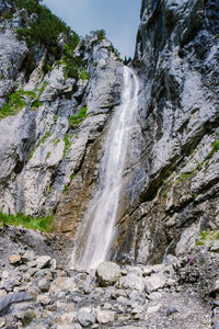 Low angle view of waterfall on rocks