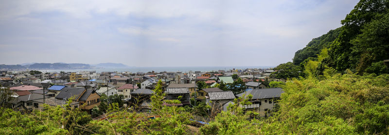 High angle view of buildings by sea against sky