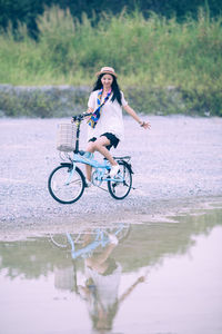 Woman cycling by puddle