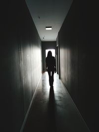 Rear view of man walking in corridor of building