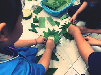 Midsection of people making decoration with leaves